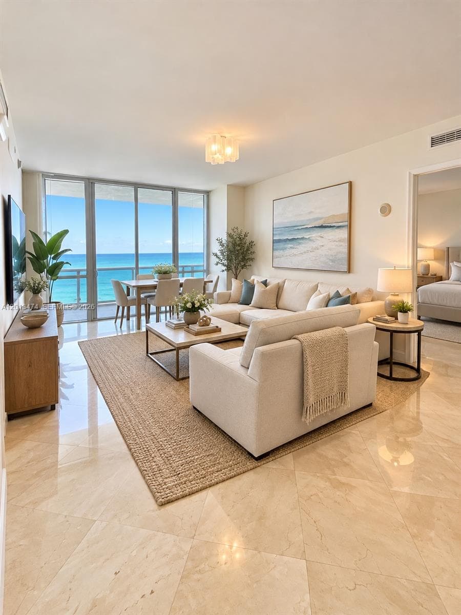 Polished stone flooring, floor-to-ceiling glass wall, and decorative ceiling fixture. Staged photo.