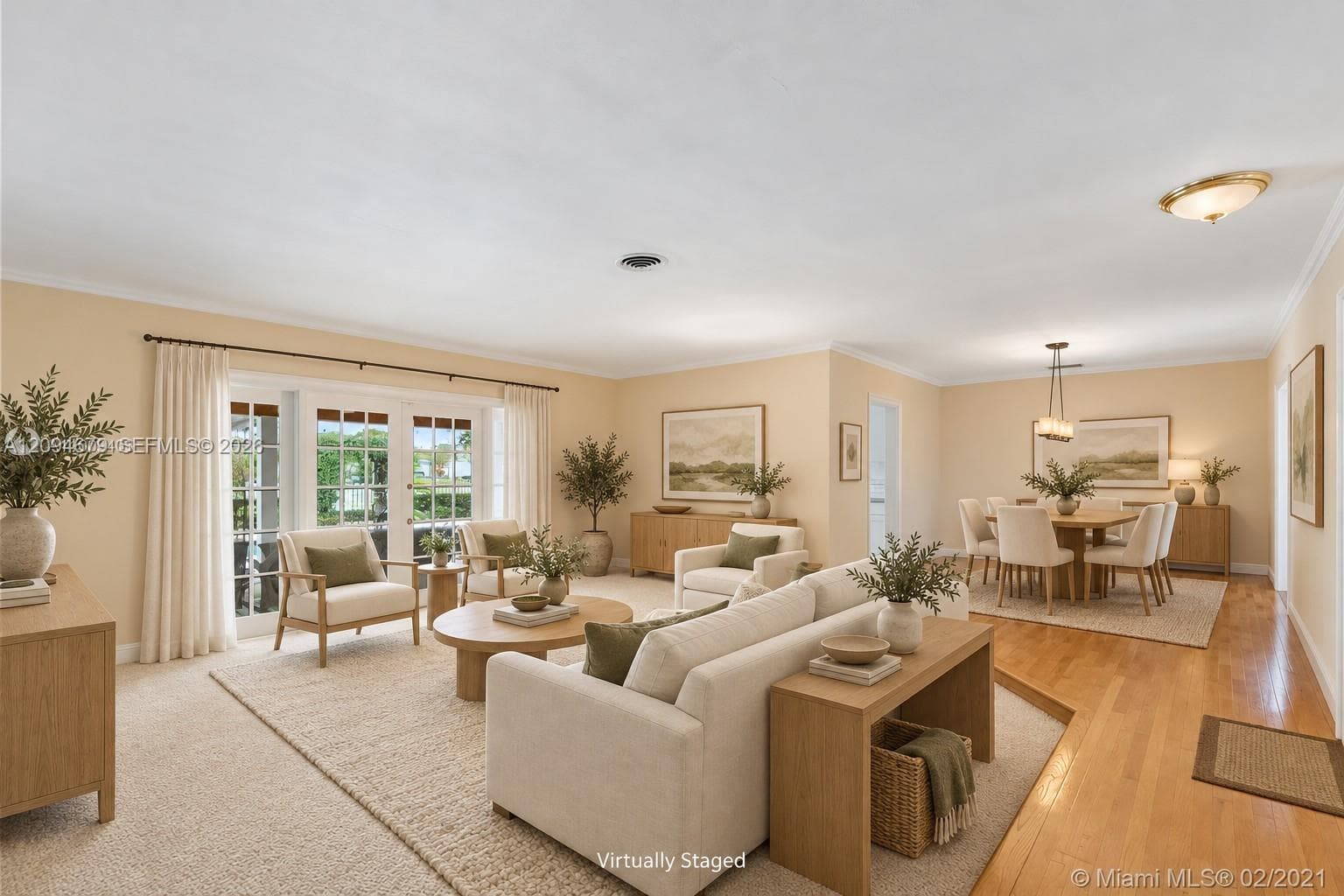 Spacious living area featuring wood-finish flooring, recessed lighting, and multi-panel glass doors with iron hardware