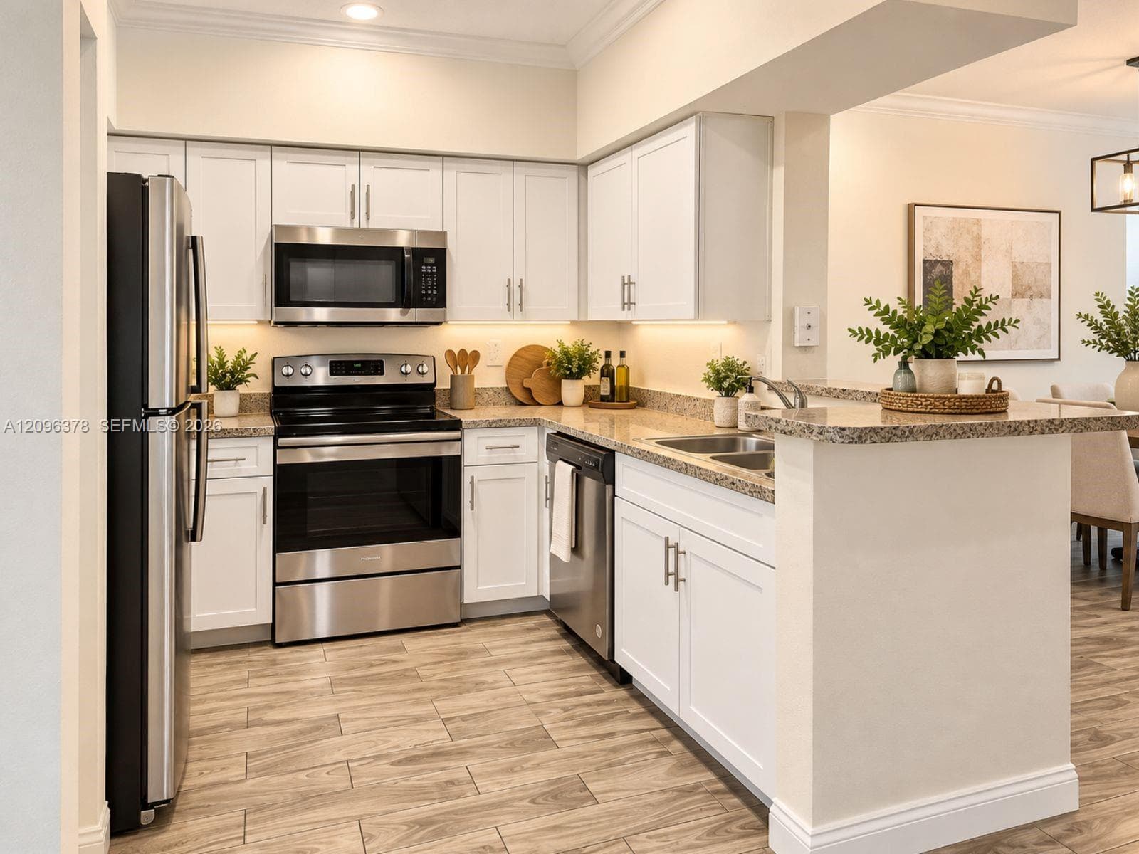 Kitchen featuring white Shaker-style cabinetry, stainless steel appliances, speckled stone countertops, and wood-finish flooring