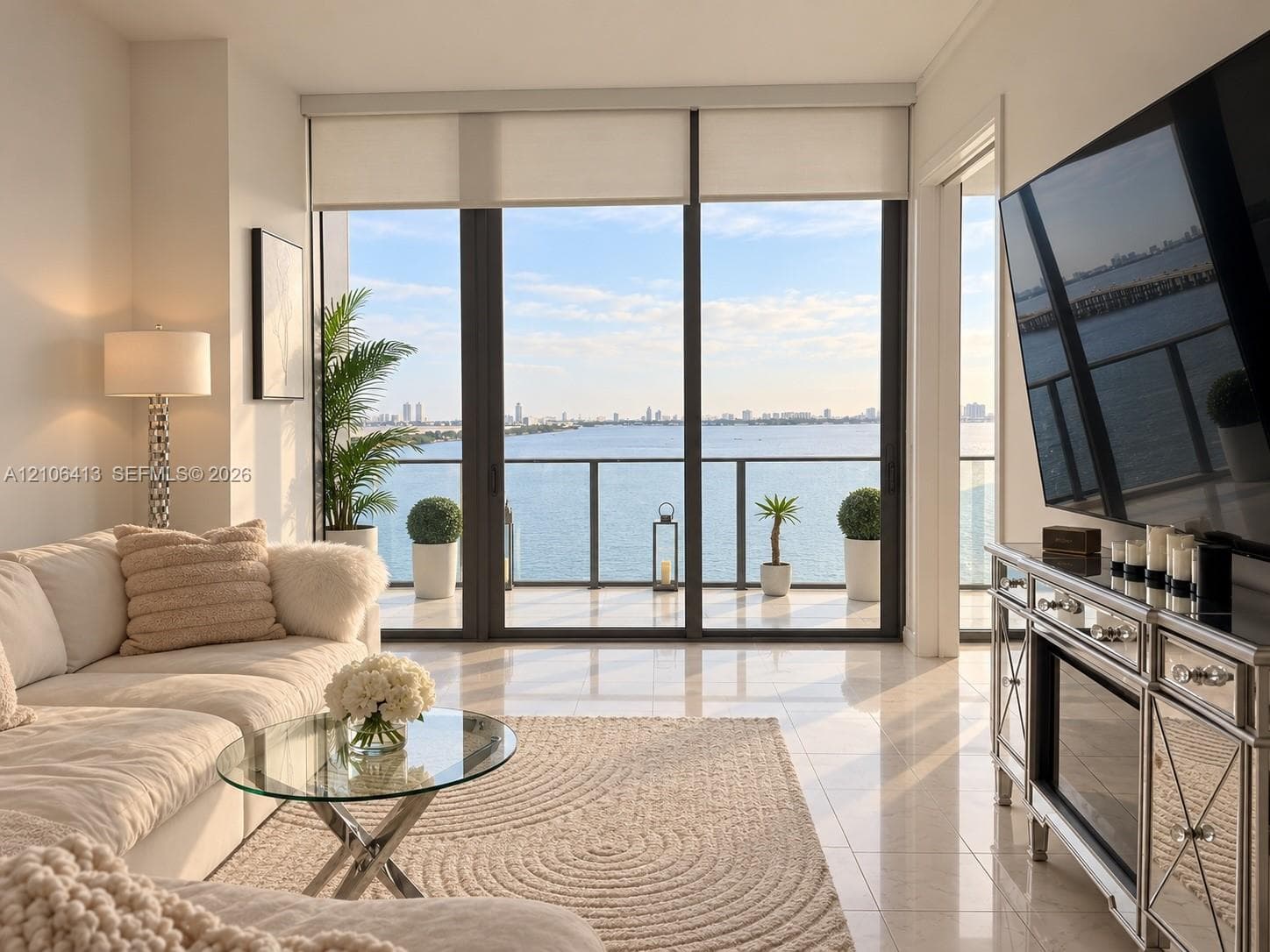 Floor-to-ceiling windows, polished tile flooring, and a private balcony featuring metal railings