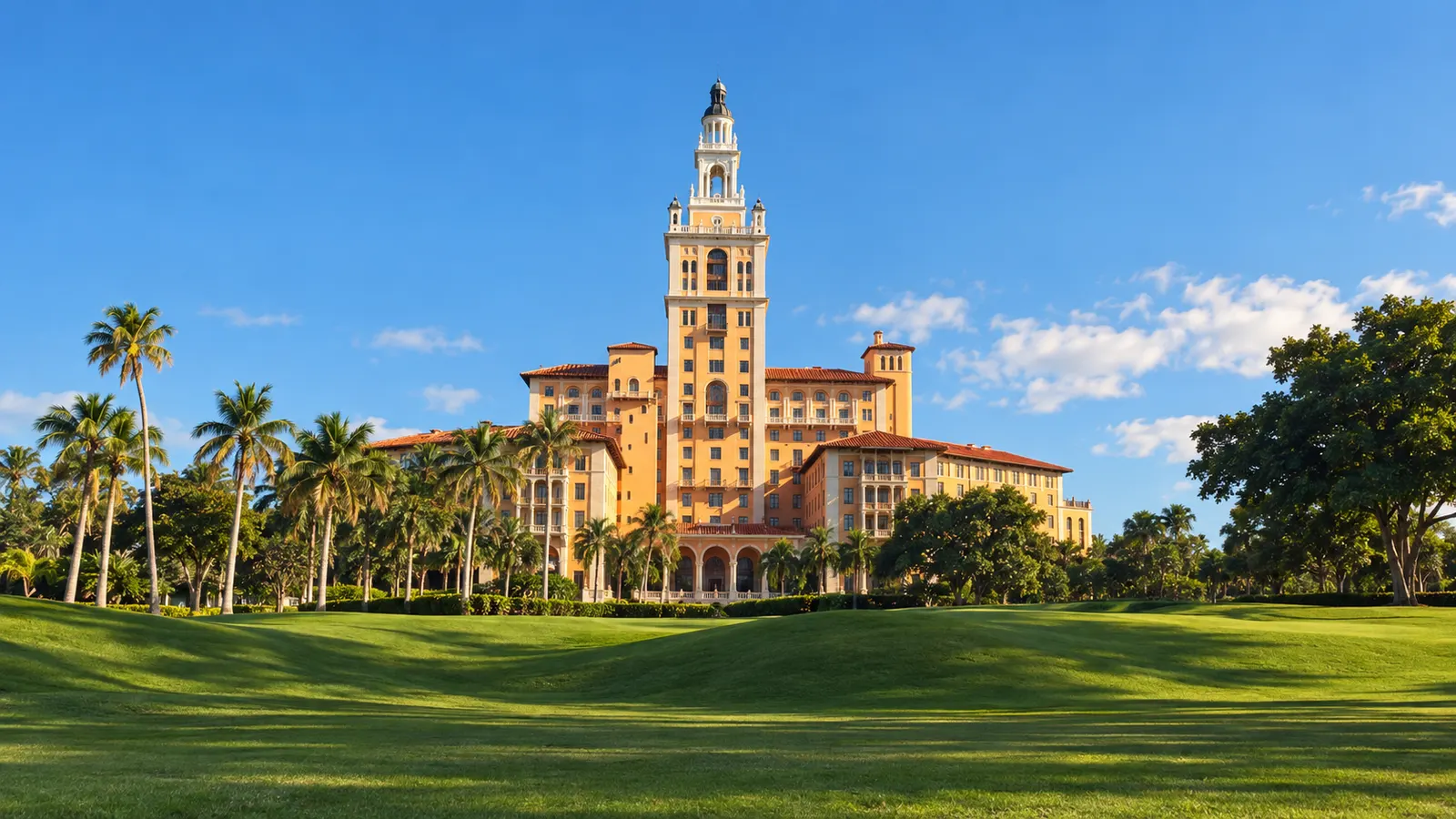 Illustrative view of the Biltmore Hotel and its tower seen across a golf-course lawn in Coral Gables