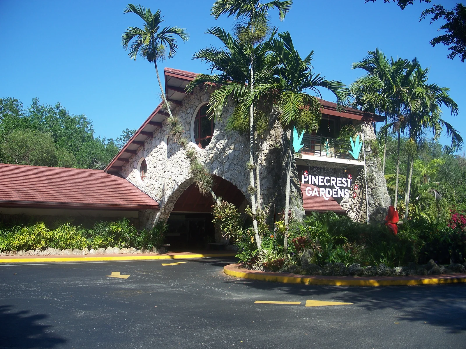 Pinecrest Gardens entrance with its identifying sign, coral-stone building and palm trees